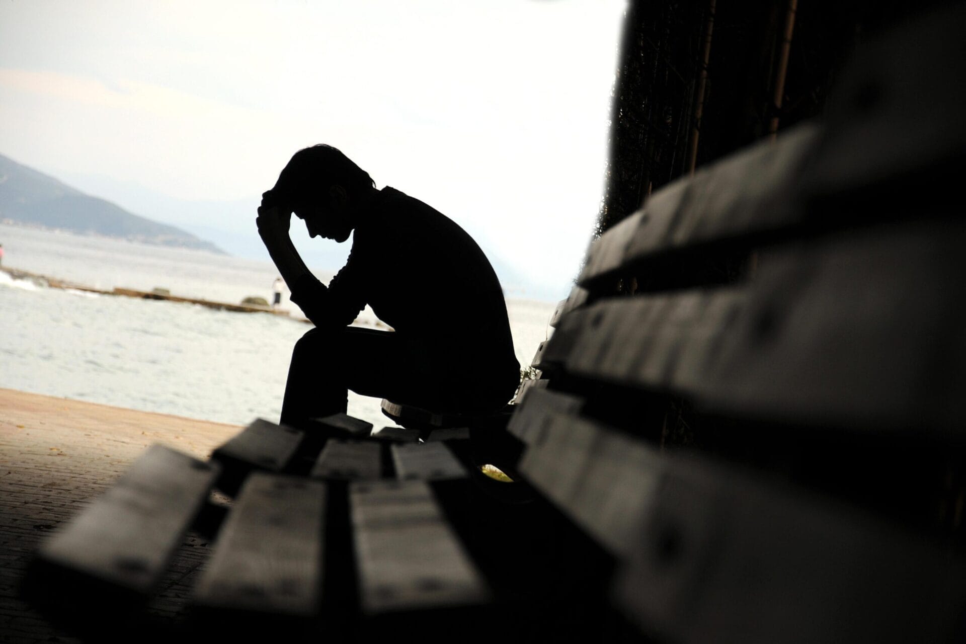 a man depressed sitting on a bench